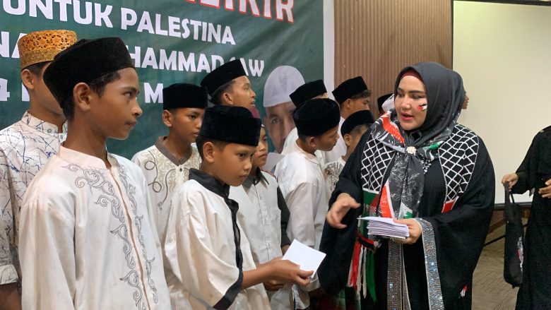 Rektor UUI Prof Adjunct Dr Marniati MKes memberikan santunan kepada anak yatim yang hadir pada acara Ubudiyah Berzikir dari Aceh untuk Palestina dan maulid Nabi Muhammad saw di halaman gedung UUI, Banda Aceh, Jumat (15/12/2023).