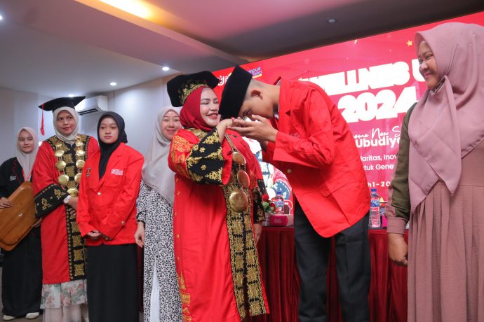 Rektor UUI Prof Adjunct Dr Marniati MKes memakaikan almamater kepada mahasiswa baru UUI 2024/2025 sebagai simbolis penyerahan mahasiswa di Plenary Hall UUI, Banda Aceh (1/10/2024).